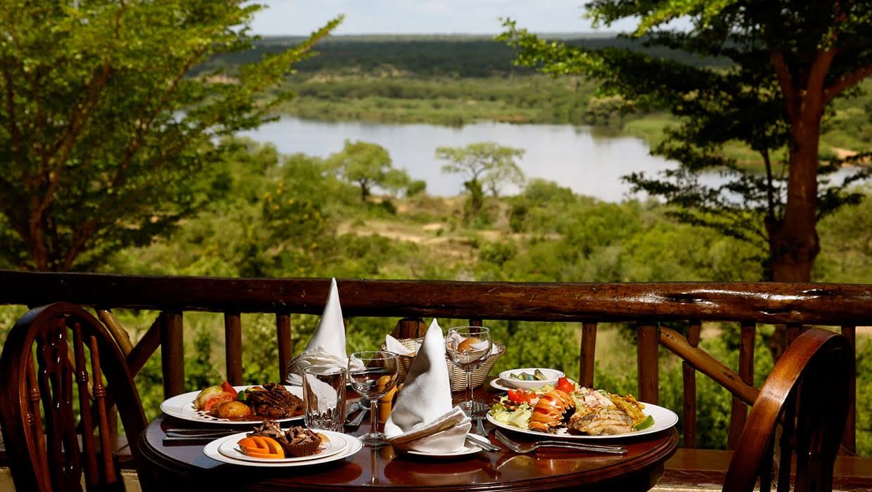 Outdoor lodge dining table overlooking a wetland