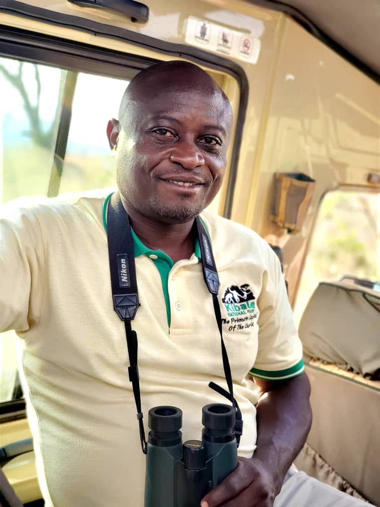 Safari guide with binoculars inside a vehicle